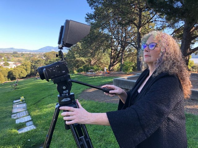 A Distant Memorials camera operator recording a graveside service